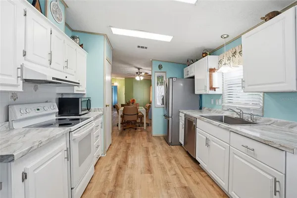 a kitchen with a sink a counter top space stainless steel appliances and cabinets