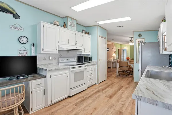 a kitchen with microwave a stove and cabinets
