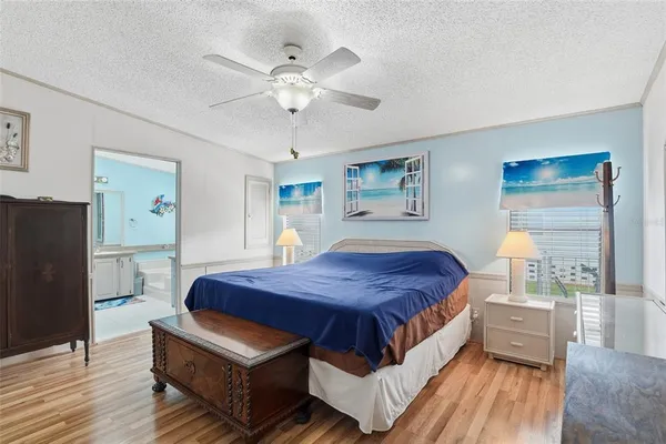 a spacious bedroom with a bed a window and dresser