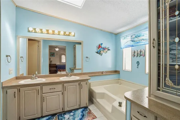a bathroom with a granite countertop tub sink and mirror