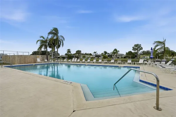 a view of swimming pool with outdoor seating and lake view