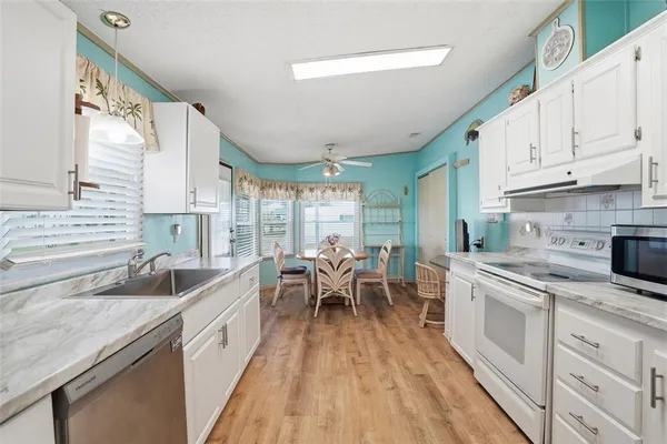 a kitchen with sink cabinets and wooden floor