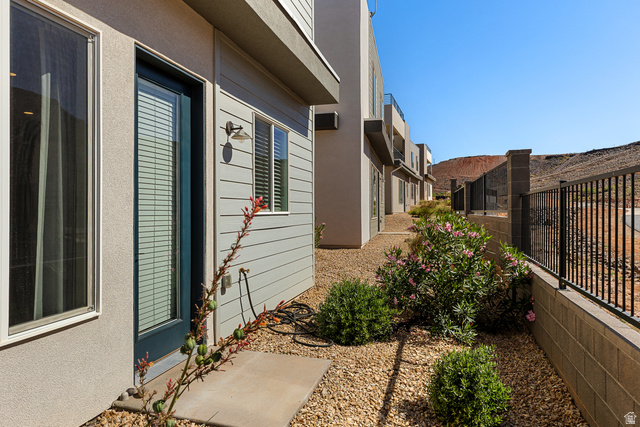 839 Walker Way St. George, UT 84770 - Photo 19 of 32 Low-maintenance xeriscaped side yard featuring gravel ground cover, mature shrubs with pink blooms, and a concrete paver path