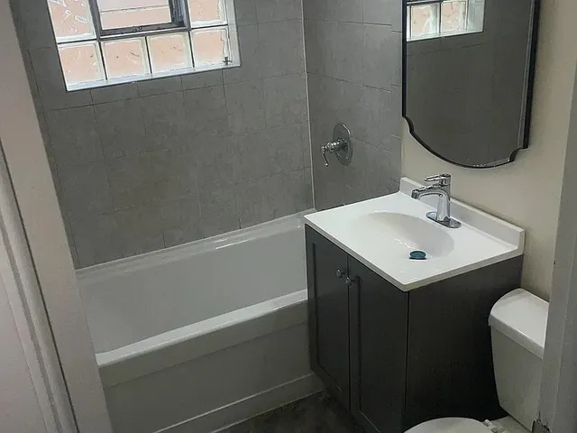 a bathroom with a sink and mirror with toilet