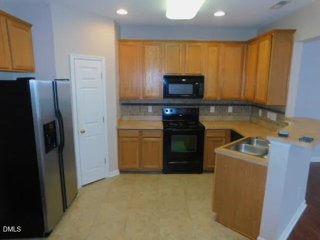 a kitchen with a refrigerator a stove top oven a sink and dishwasher