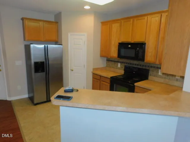 a kitchen with stainless steel appliances a refrigerator sink and microwave