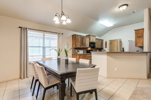 a kitchen with a table chairs microwave and cabinets