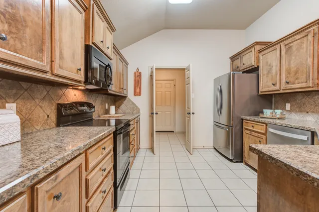 a kitchen with stainless steel appliances granite countertop a stove top oven a sink dishwasher and white cabinets
