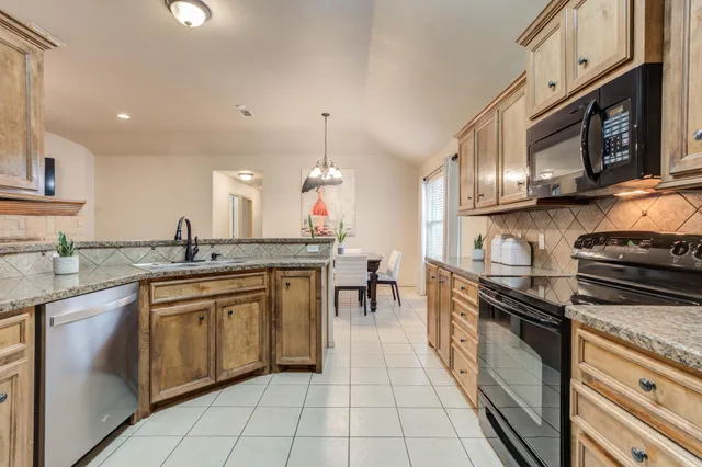 a kitchen with stainless steel appliances granite countertop a sink stove and cabinets
