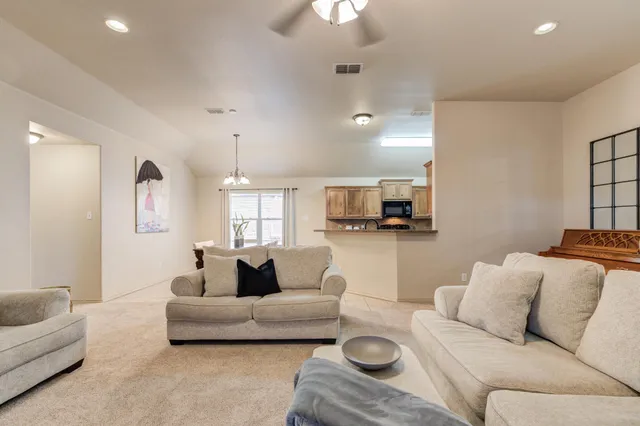 a living room with furniture and a view of kitchen