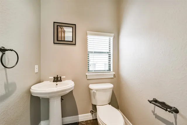 a bathroom with a sink mirror and toilet