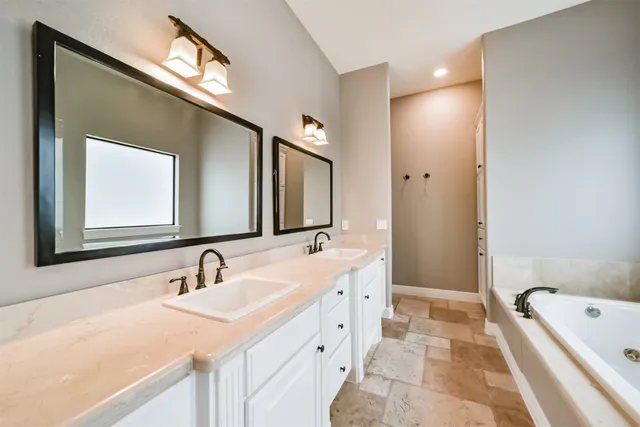 a bathroom with a tub a sink and a window