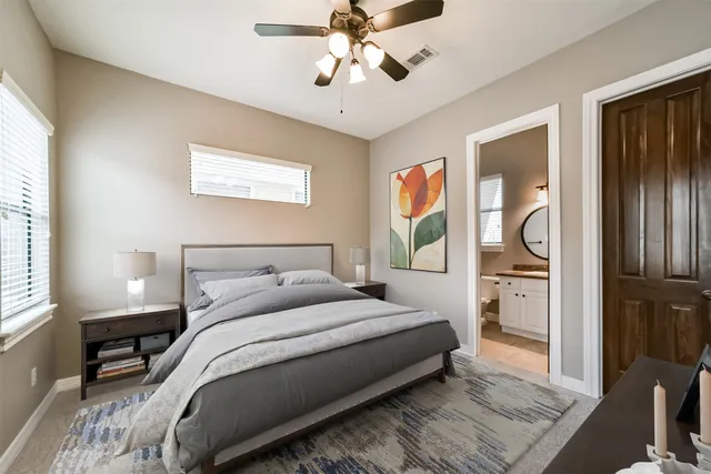 a bedroom with a bed and dresser with mirror