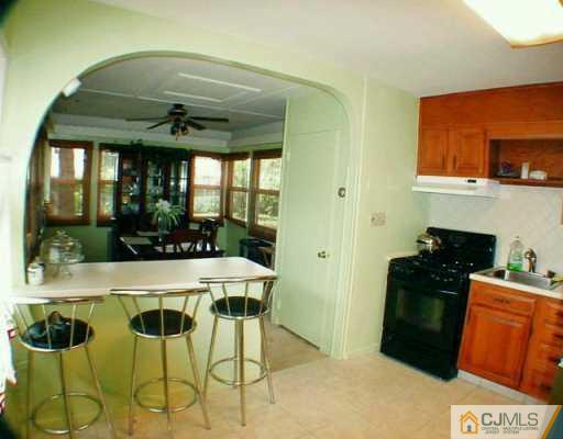 22 Caldwell Road Edison, NJ 08817 - Photo 4 of 8 a kitchen with stainless steel appliances kitchen island granite countertop a table and chairs in it