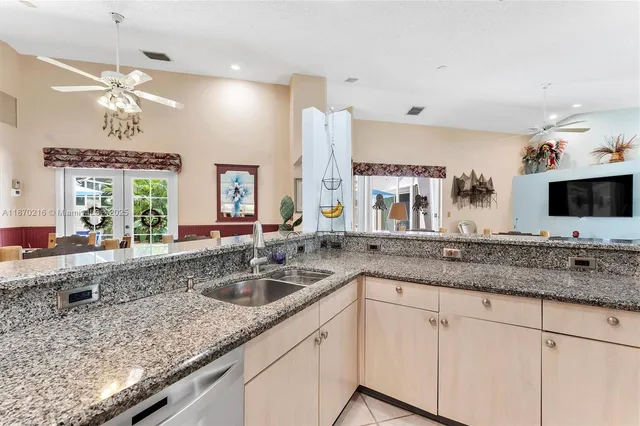 a bathroom with a granite countertop sink and a large mirror