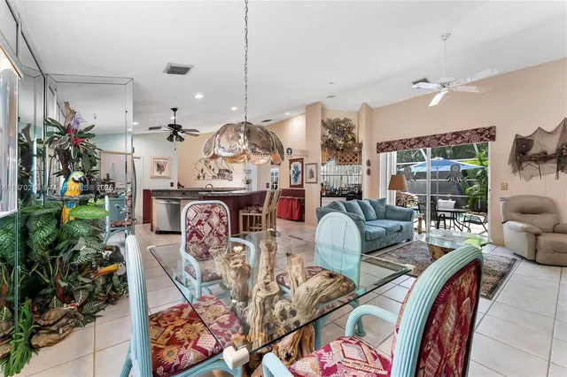 a living room with furniture a chandelier and a floor to ceiling window