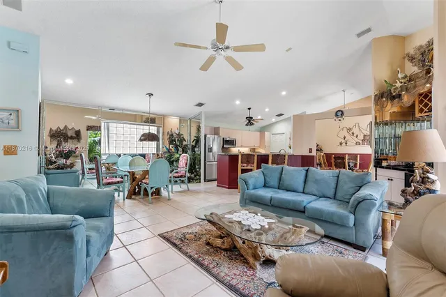 a living room with furniture kitchen view and a chandelier