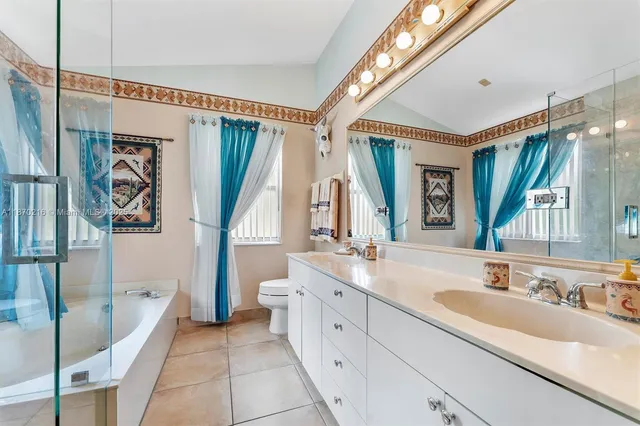 a spacious bathroom with a double vanity sink a mirror and a shower