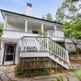a view of a house with a small yard and wooden fence