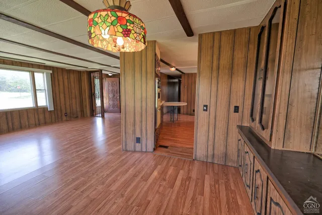 a kitchen with stainless steel appliances granite countertop a refrigerator a stove and a sink with wooden floor