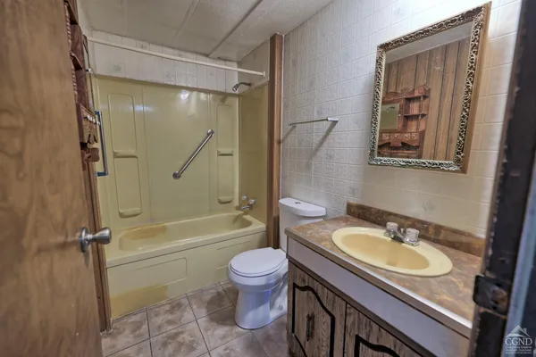 a bathroom with a granite countertop sink a mirror and a bathtub