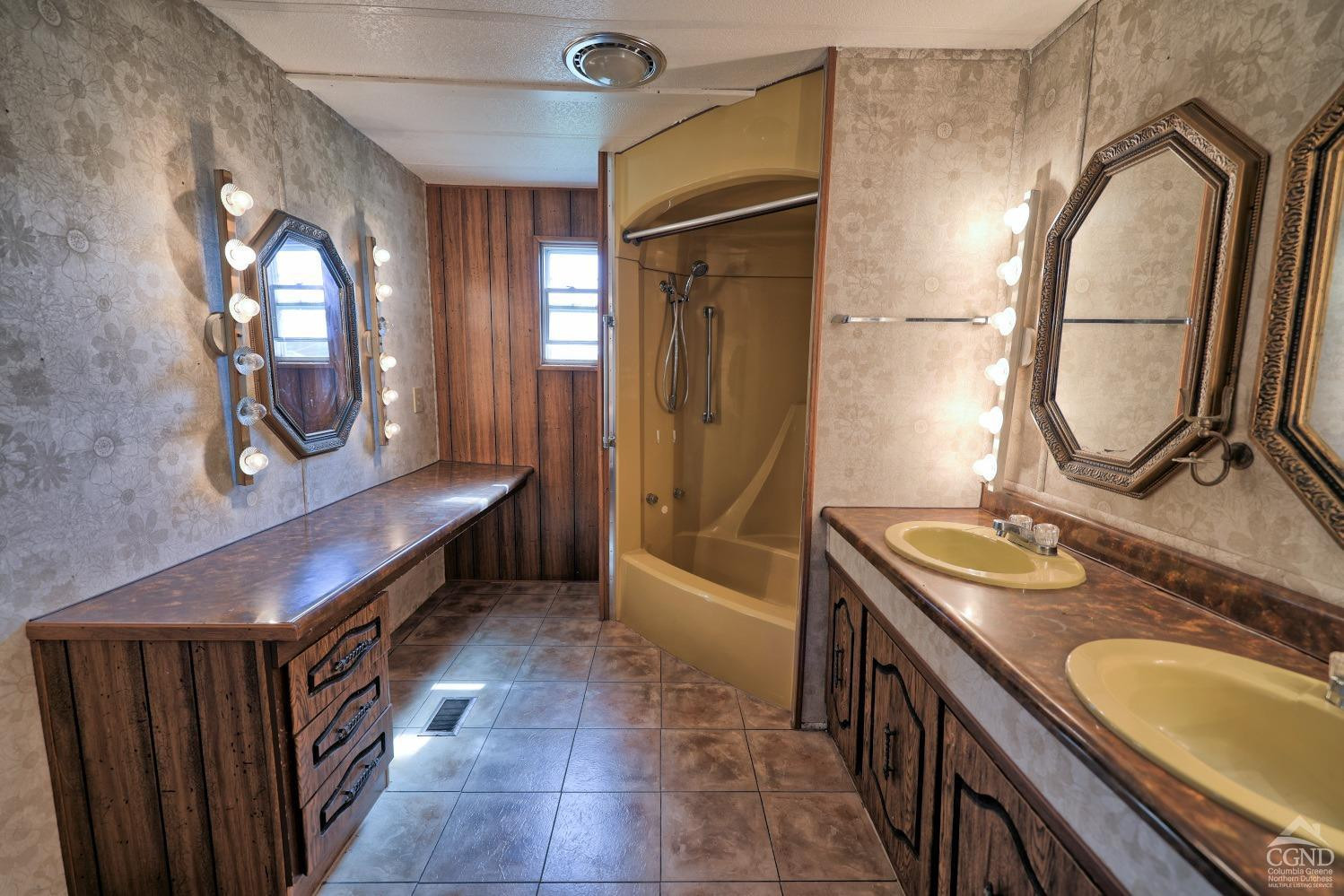 299 Main Street Cairo, NY 12413 - Photo 32 of 85 a bathroom with a granite countertop sink a mirror and a bathtub