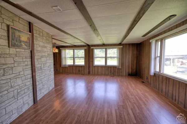 a view of a hallway with wooden floor and furniture