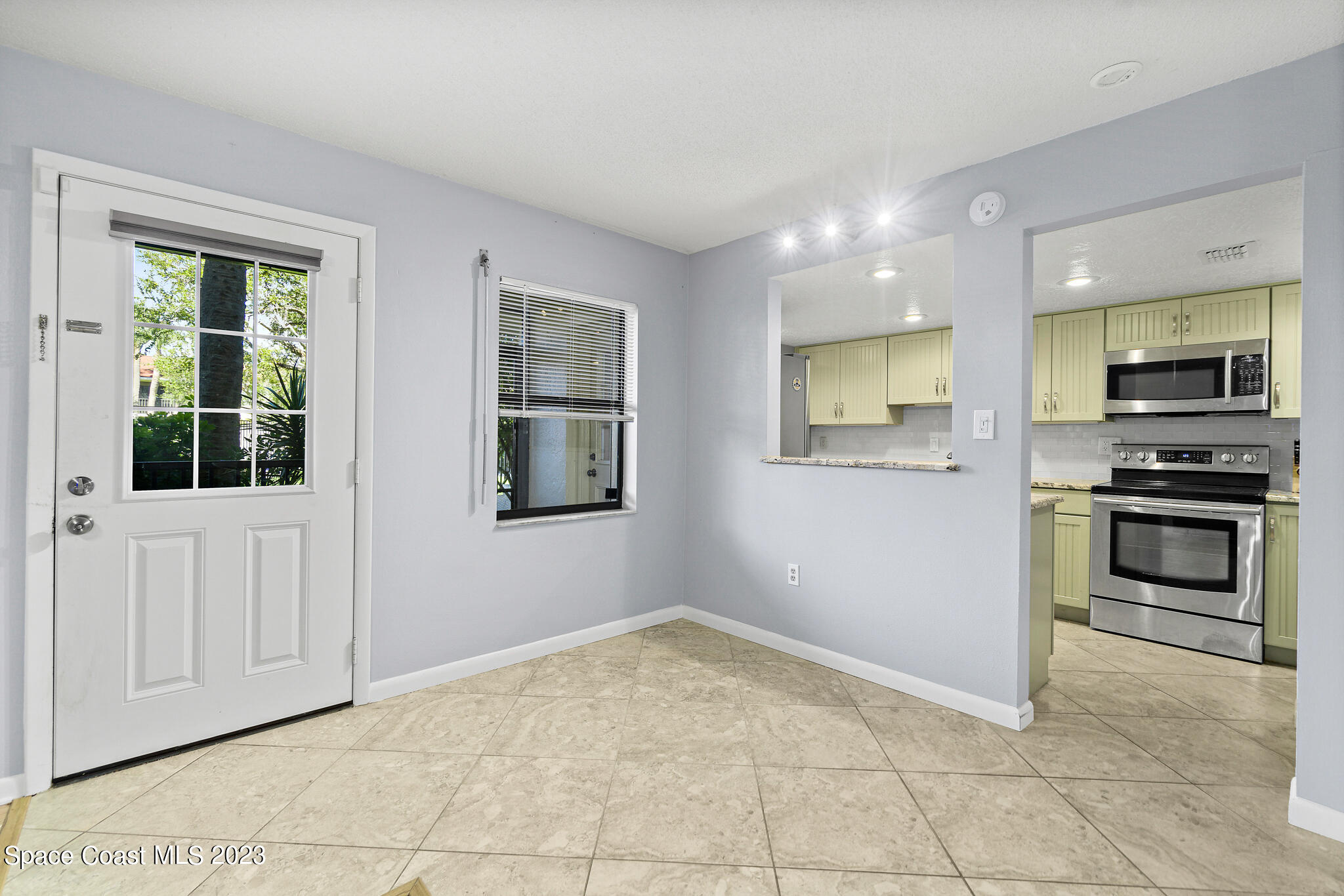500 Catalina Road, Unit 103 Cocoa Beach, FL 32931 - Photo 8 of 28 a view of kitchen with sink microwave and cabinets
