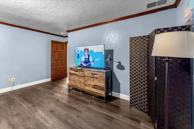 a view of a room with gym equipment and wooden floor