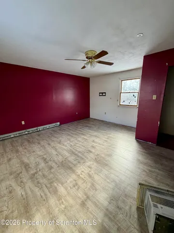 a view of an empty room with window and fireplace