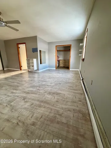 a view of empty room with kitchen and window