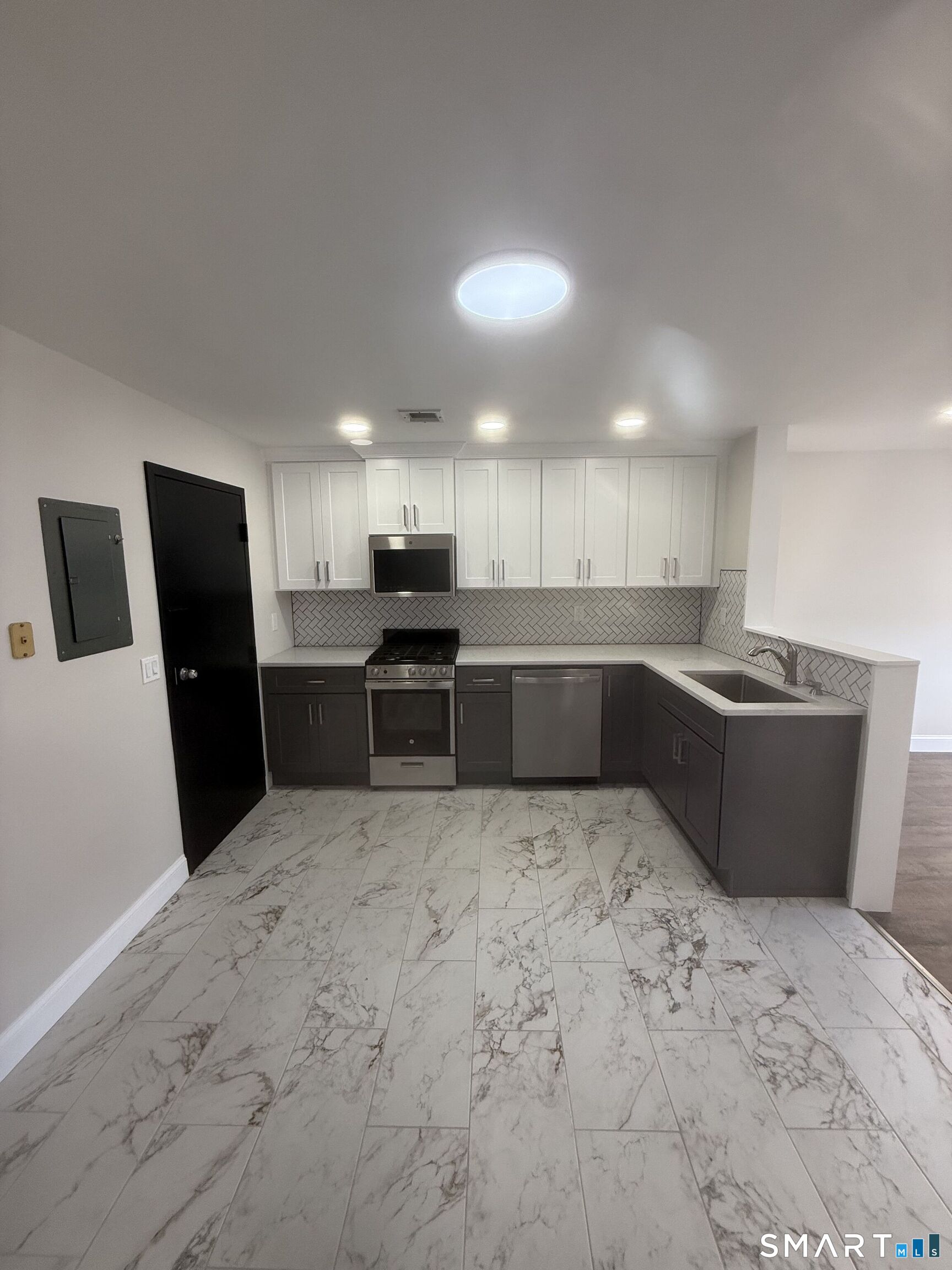 a kitchen with stainless steel appliances kitchen island granite countertop a refrigerator sink and cabinets
