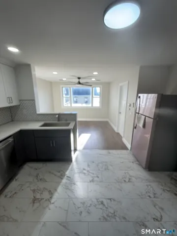 a large kitchen with a stove a sink dishwasher and a refrigerator