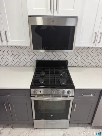 a stove top oven sitting inside of a kitchen