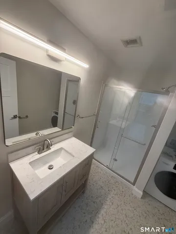 a bathroom with a sink a mirror and a shower