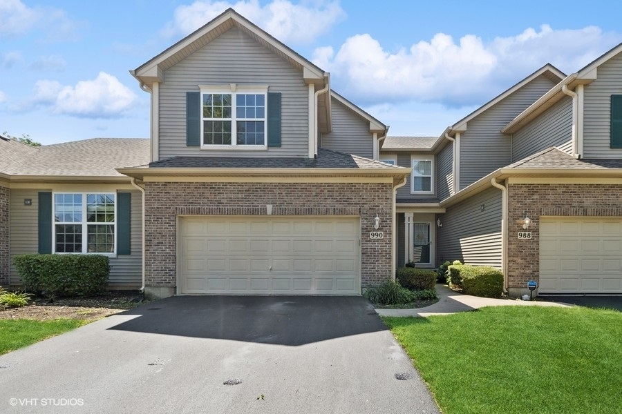 990 Oak Ridge Boulevard Elgin, IL 60120 - Photo 1 of 19 a front view of a house with a garden and garage