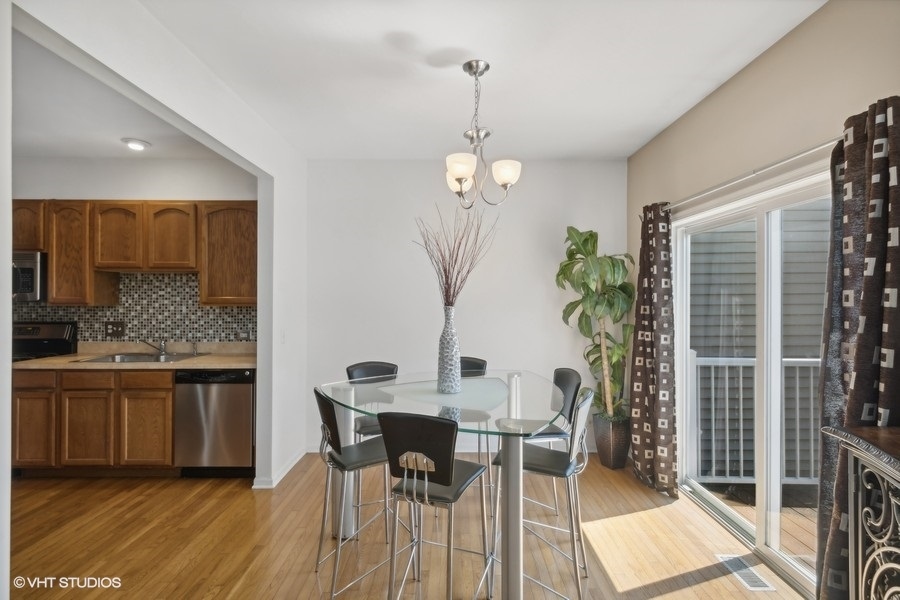 990 Oak Ridge Boulevard Elgin, IL 60120 - Photo 5 of 19 a dining room with furniture a chandelier and wooden floor