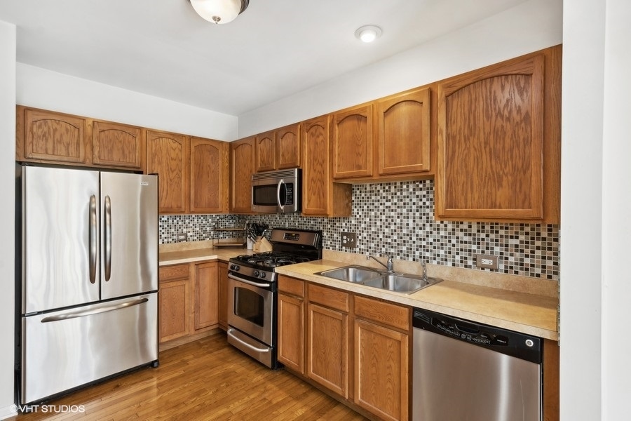 990 Oak Ridge Boulevard Elgin, IL 60120 - Photo 6 of 19 a kitchen with stainless steel appliances granite countertop a refrigerator sink and cabinets