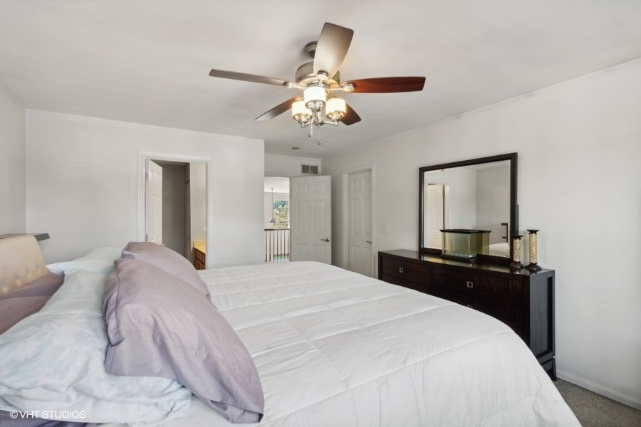 990 Oak Ridge Boulevard Elgin, IL 60120 - Photo 10 of 19 a bedroom with a bed and a chandelier