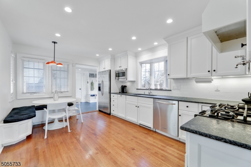 9 Hawthorne Road Short Hills, NJ 07078 - Photo 5 of 25 a kitchen with stainless steel appliances granite countertop a sink dishwasher a stove and white cabinets with wooden floor