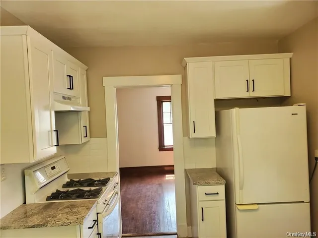a kitchen with a refrigerator and a stove
