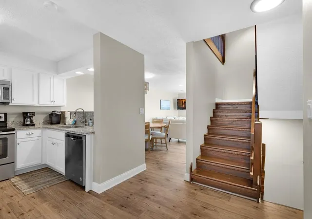 a kitchen with cabinets and wooden floor