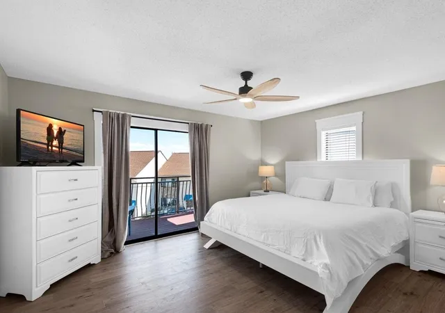 a bedroom with a large bed and a flat tv screen