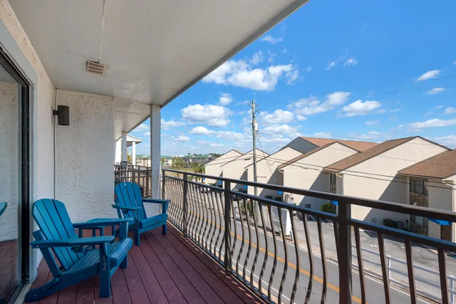 a view of a balcony with furniture and wooden floor