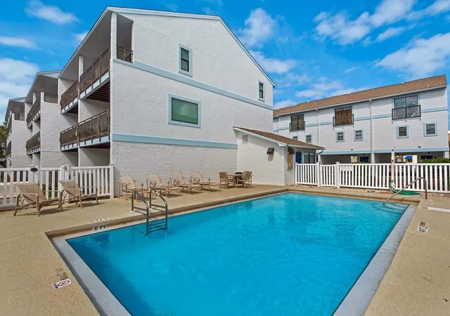 a view of a house with pool and sitting area