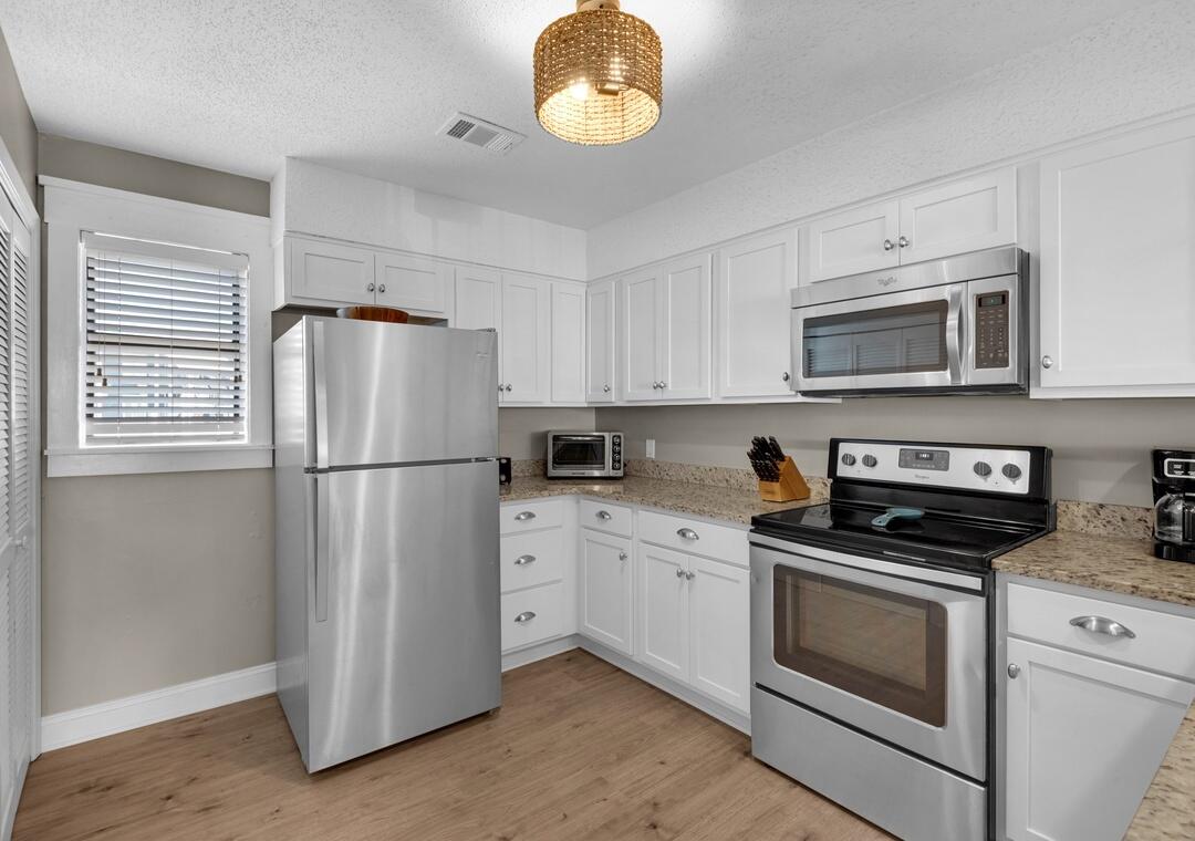 11 Driftwood Road, Unit 9 Miramar Beach, FL 32550 - Photo 9 of 30 a kitchen with cabinets stainless steel appliances and a counter space