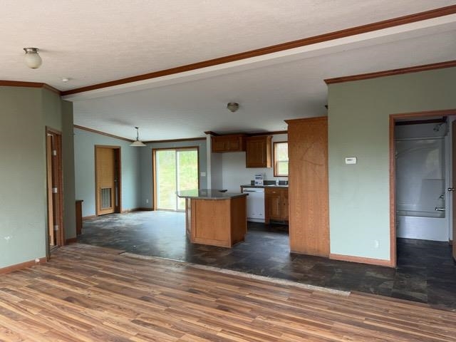 1335 Big Noise Pit Road Two Harbors, MN 55616 - Photo 20 of 20 Kitchen featuring white dishwasher, dark wood finished floors, ornamental molding, baseboards, and open floor plan
