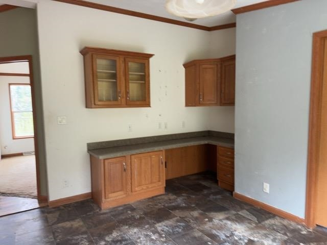 1335 Big Noise Pit Road Two Harbors, MN 55616 - Photo 7 of 20 Kitchen featuring baseboards, brown cabinetry, ornamental molding, dark stone finish flooring, and dark countertops