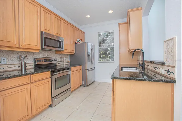 a kitchen with stainless steel appliances granite countertop a sink a stove and a refrigerator