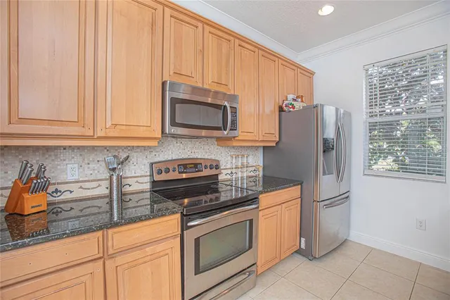 a kitchen with granite countertop a refrigerator sink and microwave